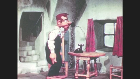 1950s: Marionette puppet sits down at table, picks up phone, puts phone to head, Stock Footage 79474863