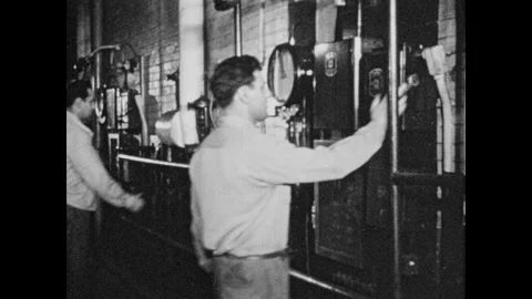 1950s: Men adjust levers and knobs on wall. Machine planes and smooths wooden 스톡 동영상 89618502