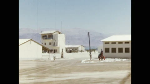 1950s: Men and women smile. View of buildings from road. Manufacturing Stock Footage
