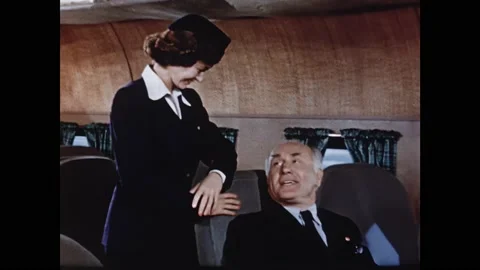 1950s: Men lean over seats and talk on plane. Stewardess and passenger talk on Stock Footage 165426290