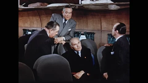 1950s: Men lean over seats and talk on plane. Stock Footage 165426302