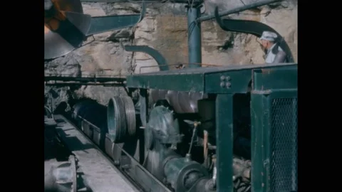 1950s: Men operating huge drilling machine. Fabric lowered into hopper by Stock Footage 221102990
