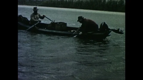 1950s: Men remove drift nets from river and remove captured fish. Stock Footage 103555607