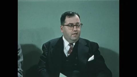 1950s: Men in suits talk around conference table. Finger points at map of Vídeos de archivo 238929692