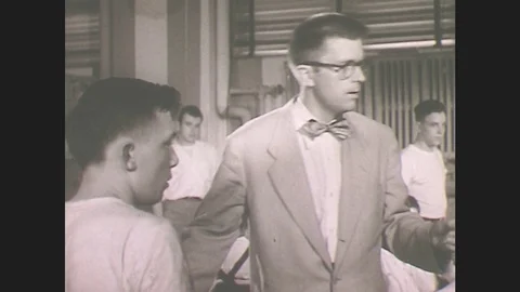 1950s: Men talk.  Man makes phone call.  Switchboard operator connects calls.  Stock Footage 79816001