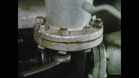 1950s: Men use wrenches to tighten nuts on pipe flange. Man monitors paper mill Видео 155114140