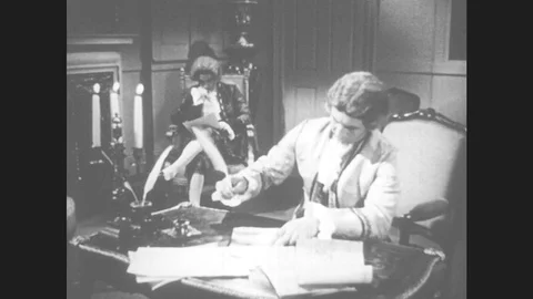 1950s: Men work in room. Man sits at desk. Man writes. Man lifts paper and Stock Footage