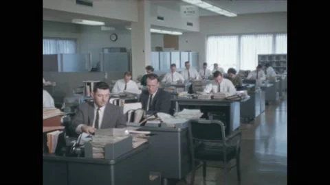 1950s: men working at desks in office, man taking book down from shelves and Stock Footage 171880025