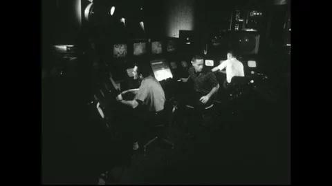 1950s: Men working TV control room / Pan across shows on TV monitors. Stock Footage 74760759