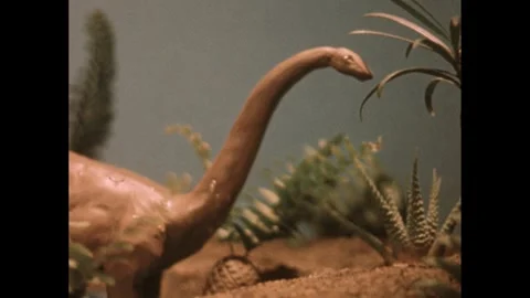 1950s: Model of brontosaurus stands on display in diorama. Video stock 243825807