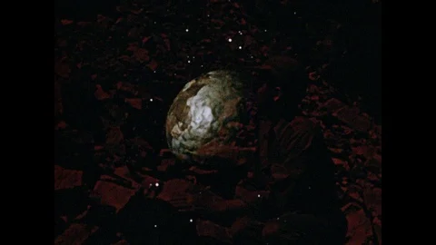 1950s: Model of earth rotating in orbit. Volcanic landscape with the word Stock Footage 104097032