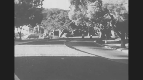 1950s: Motorcycle Police Chase Suspects Car Through Streets. Girl Leans From Stock Footage