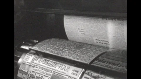 1950s: Newspaper printing from roller. Close up, paper running through machine. Stock Footage 112471937