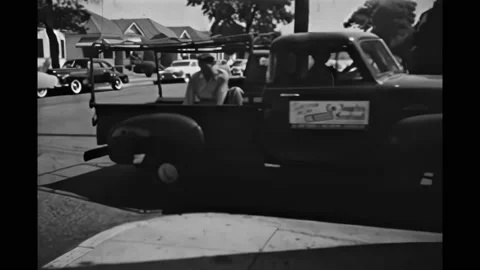 1950s: Newspaper sheets rolling off press. Man in bed of truck throwing Stock Footage 166397840