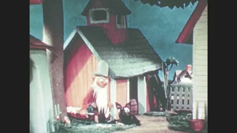 1950s: Old man puppet with long white beard sits outside with dog. Bird puppet Stock Footage 79474969