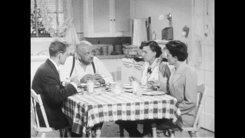 1950s: Parents, son, daughter sit at kitchen table, father talks to daughter. Stock Footage