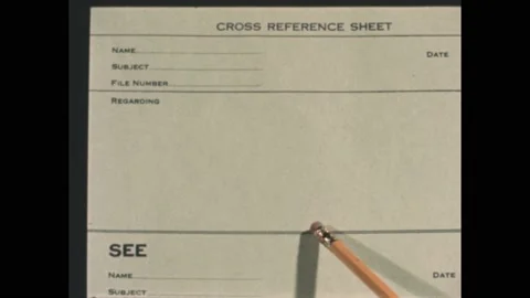1950s: Pencil points to a cross reference sheet. Secretary at a desk talks and Video stock 172025033