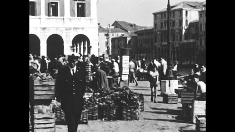 1950s: People move around, Goods in crates. Man carries crate of fresh produce. Stock Footage