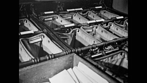 1950s: Postal workers sort mail.  Train moves down tracks.  Post office.  Man Stock Footage 157457309
