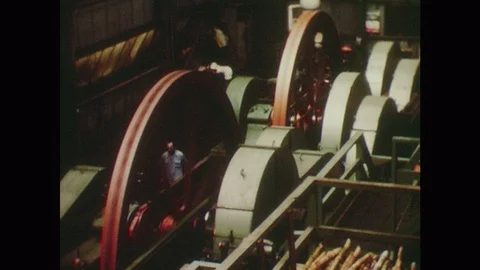1950s: Pulleys turn in sugar mill. Rollers crush sugarcane in machine. Man Stock Footage 124337364