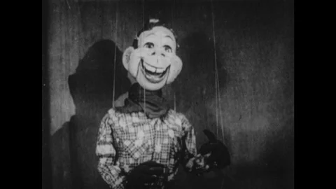 1950s: Puppet speaks.  Clown claps.  Fireplace.  Man hides behind chair.  Man Stock Footage 100095214