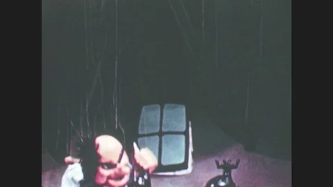 1950s: Puppet talks angrily on phone. Devil and angel puppets appear, devil Stock Footage 79474972