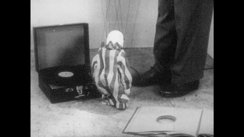 1950s: Puppet walks to man and cries against his leg.  Marionette turns and Stock Footage 83825354