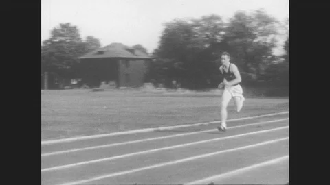 1950s: Running man jumps three hurdles on track. Slow motion side view replays Vídeos de archivo 85617246