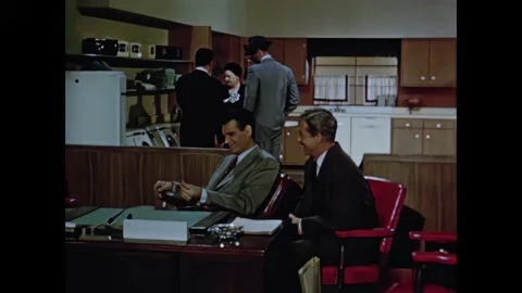 1950s: Salesman pulls hat over eyes and wanders from closed store. Men talk at Video stock 165426039