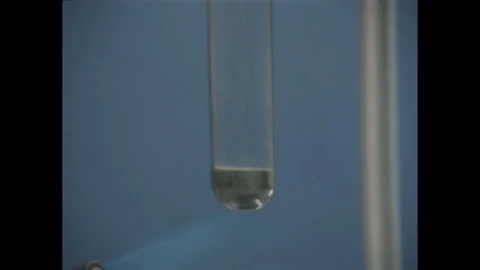1950s: small amount of clear liquid at bottom of glass test tube, flame from 스톡 동영상 279488598
