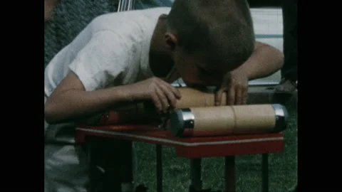 1950s: Small boy cavorts in front yard with family playing croquet. Stockbeeldmateriaal 148582147