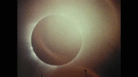 1950s: Solar eclipse.  Flag reads "NATIONAL GEOGRAPHIC SOCIETY."  Men move cargo Vídeo Stock 146678511