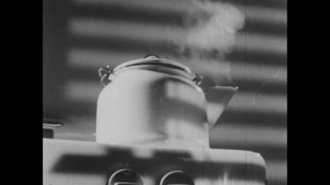 1950s: Steam blows from train engine and tea kettle. Train drives along railroad Stock Footage 295213222