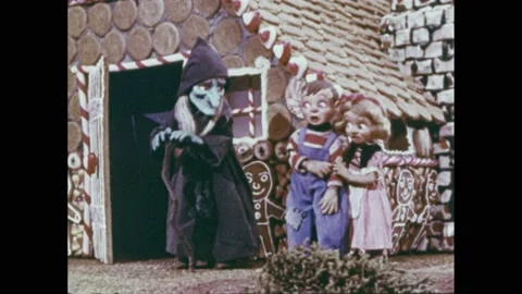 1950s: Stop-motion puppet animation- Boy and girl walk into gingerbread house Stock Footage 205765553