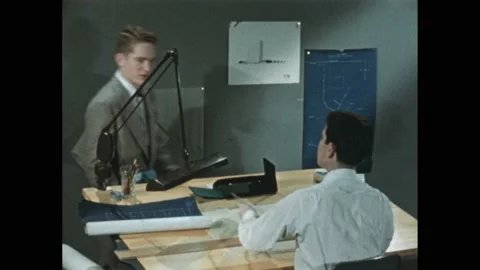 1950s: student seated at drafting table working when teacher comes over to check Vidéo 171879942