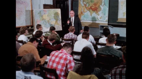 1950s: Students sit in class, listen to lecture. Writing on chalkboard. Stock Footage 113939358