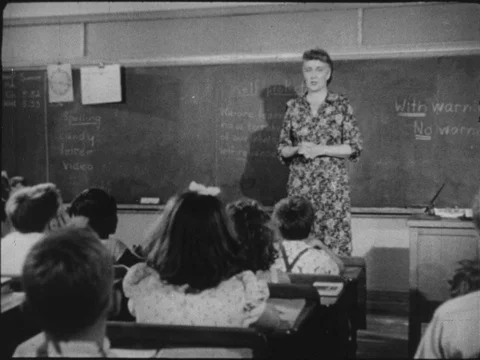 1950s: Teacher stands at head of elementary school classroom filled with student Stock Footage
