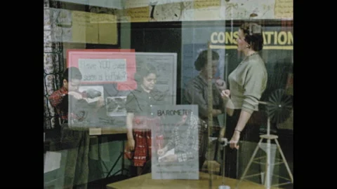1950s: Teacher talks to three students working on class presentation. Woman in Stock Footage 147205199
