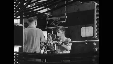 1950s: Technicians ready guide tube on a particle accelerator. Cyclotron Stock Footage