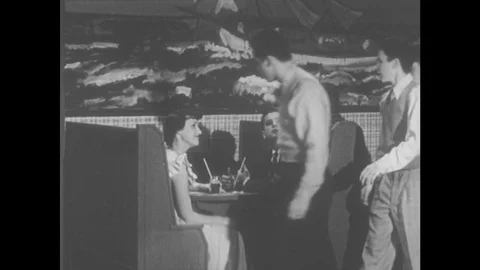 1950s: Teenage Boy And Teenage Girl Sit In A Soda Fountain Booth Talking Stock Footage