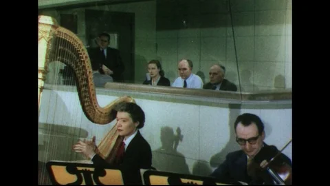 1950s: Tilt across orchestra, musicians playing. Stock Footage