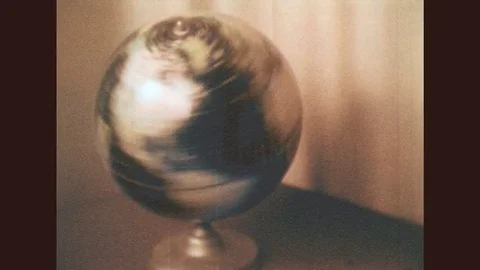 1950s: Title card for "FOREIGN LANGUAGE" over spinning globe. Globe spin slows. Stock Footage 78075509