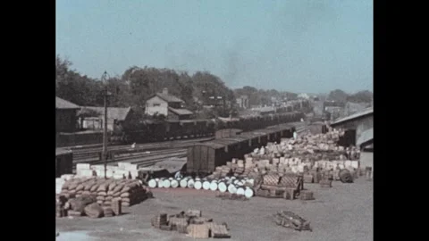 1950s: Train pulls through loading station. Docked ship in harbor. Ship docked Video stock 303587999