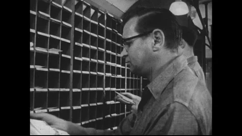 1950s : As the train rolls, postal workers continue sorting mail while keeping a Vidéo 74504165