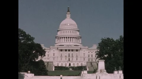 1950s: Trees stand outside Capitol Building in Washington DC. Tourists walk on Video stock 244408586