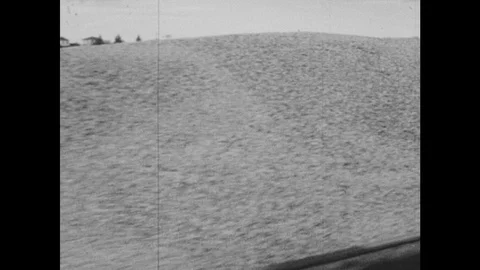 1950s: Truck full of wheat pulls up to the Okotoks grain elevator. Trucks pull Stock Footage 126010336