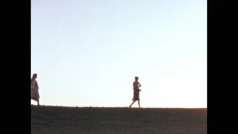 1950s: Two figures walk on horizon, sowing seeds. Vidéo 164797697