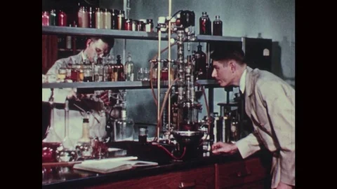 1950s: Two men work in a chemist lab. Men work at logging mill. Man works on Stock Footage 77223139