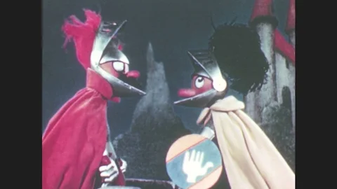 1950s: Two puppets dressed as knights fistfight on top of bridge. Puppet knights Stock Footage 79474944