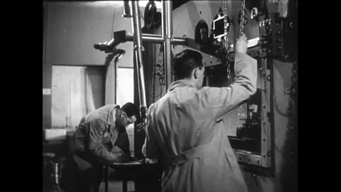 1950s: Two scientists operate a robotic arm, via remote control, to work with Stock Footage